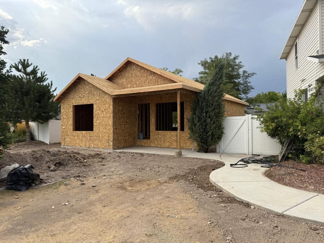 Sheathed addition with a gabled roofline and covered porch from the front