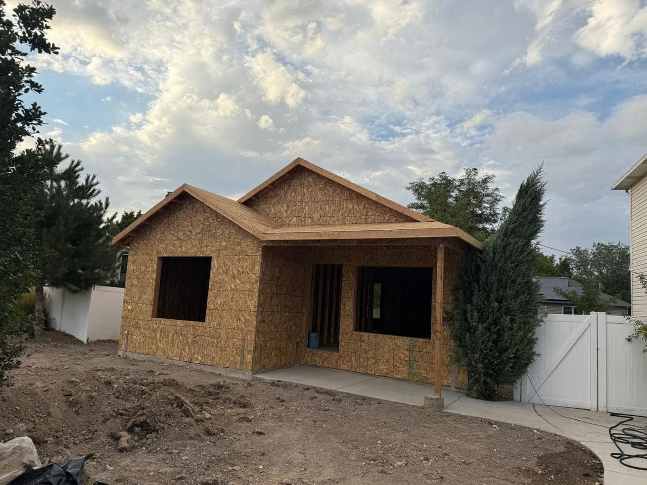 Front of the addition showing roof sheathing, porch and concrete walkway