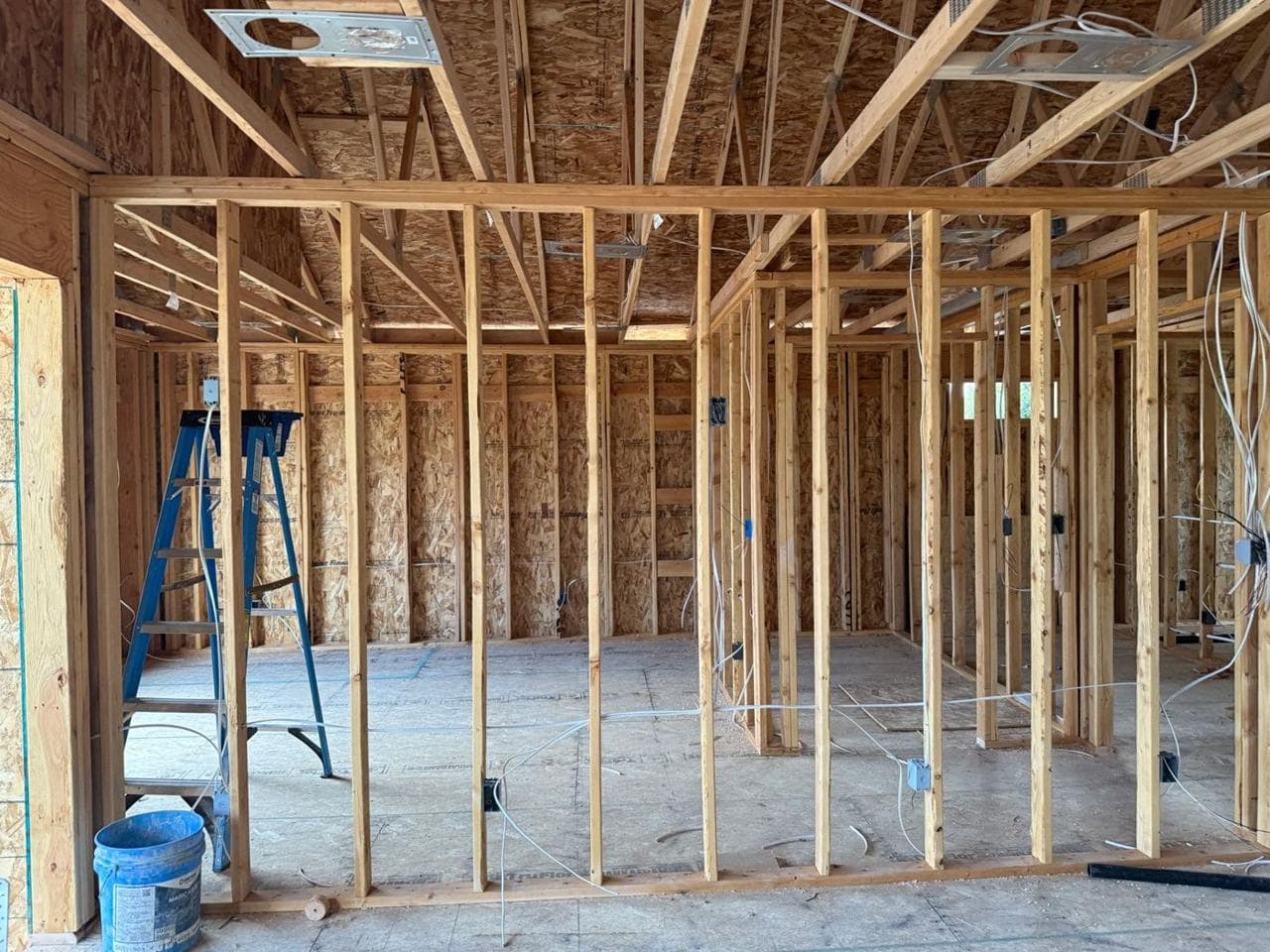 Open interior framing with a ladder, wiring and electrical boxes
