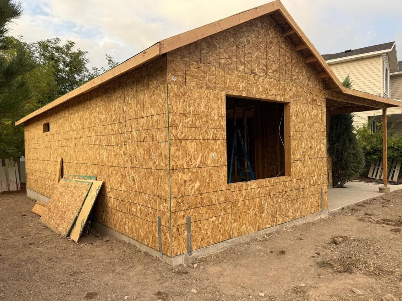 Side wall of the addition with a large window opening and roof overhang