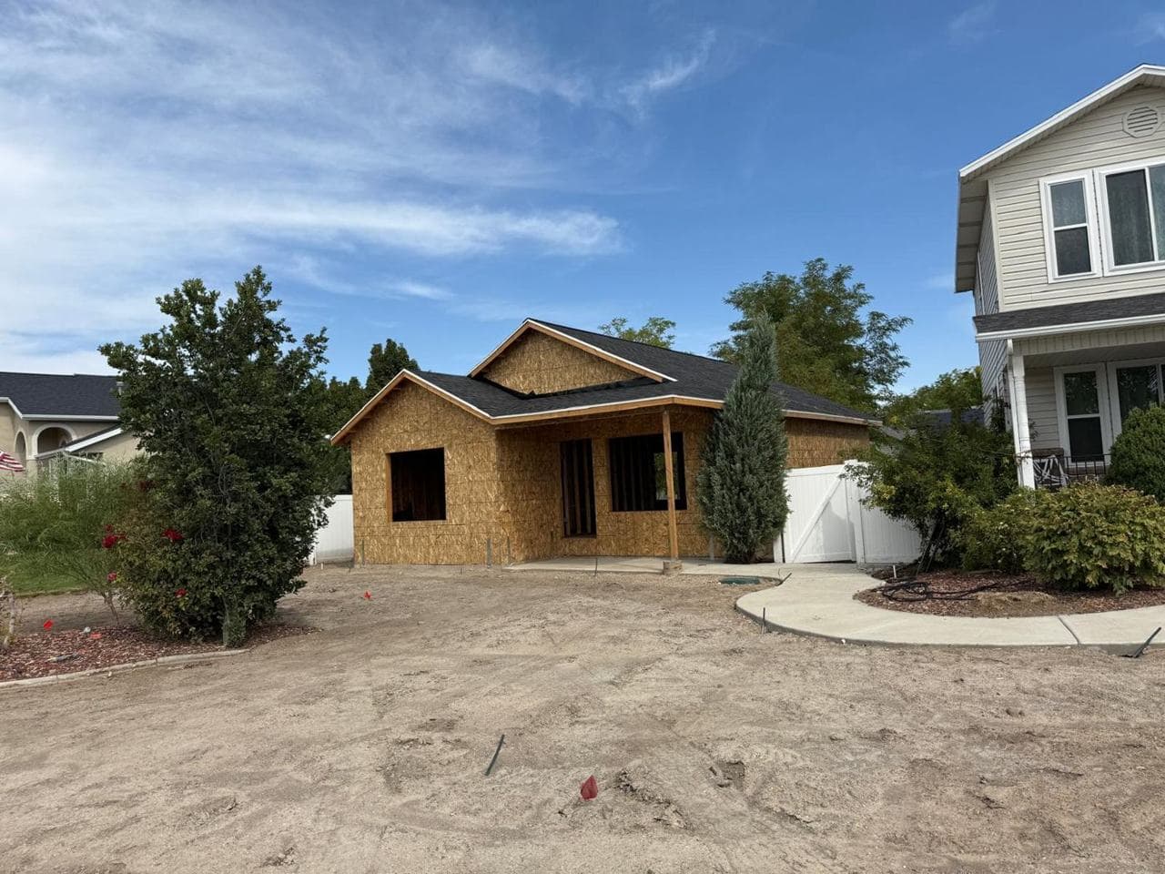 Addition with shingled roof and porch as seen from the yard
