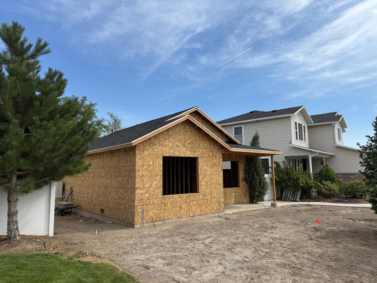 Corner view of the addition with roof, porch and existing home behind