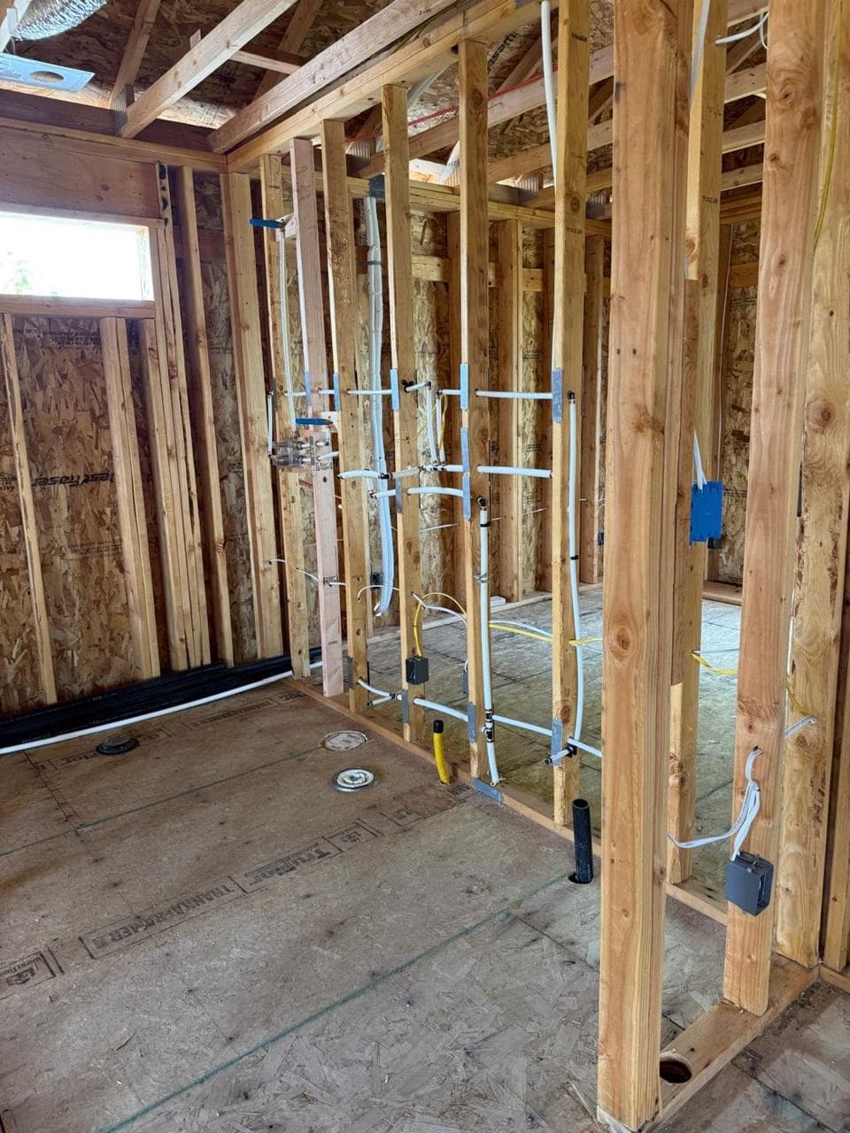 Plumbing and electrical rough-in inside a framed wall
