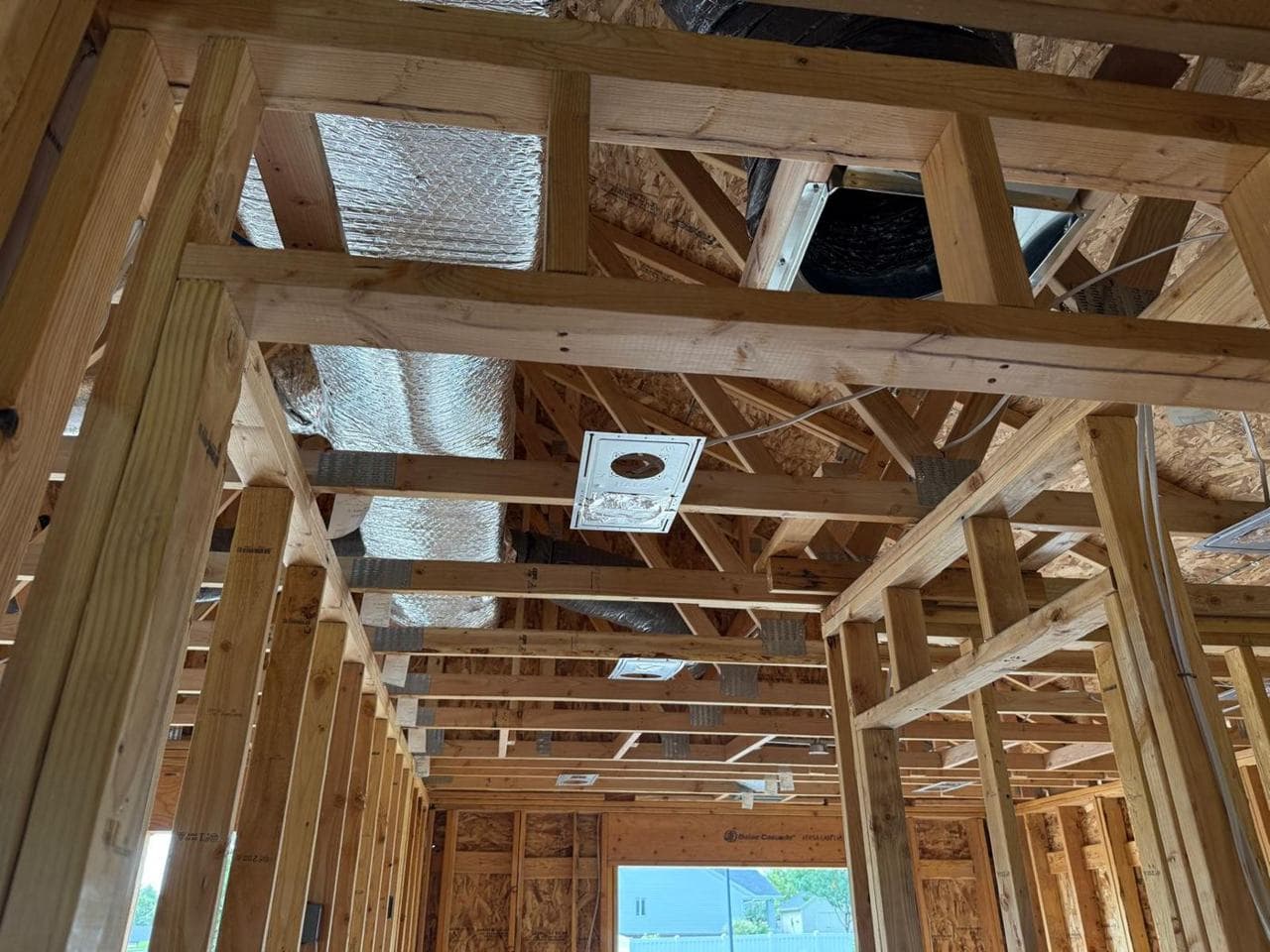 Ductwork and a recessed light housing between ceiling joists