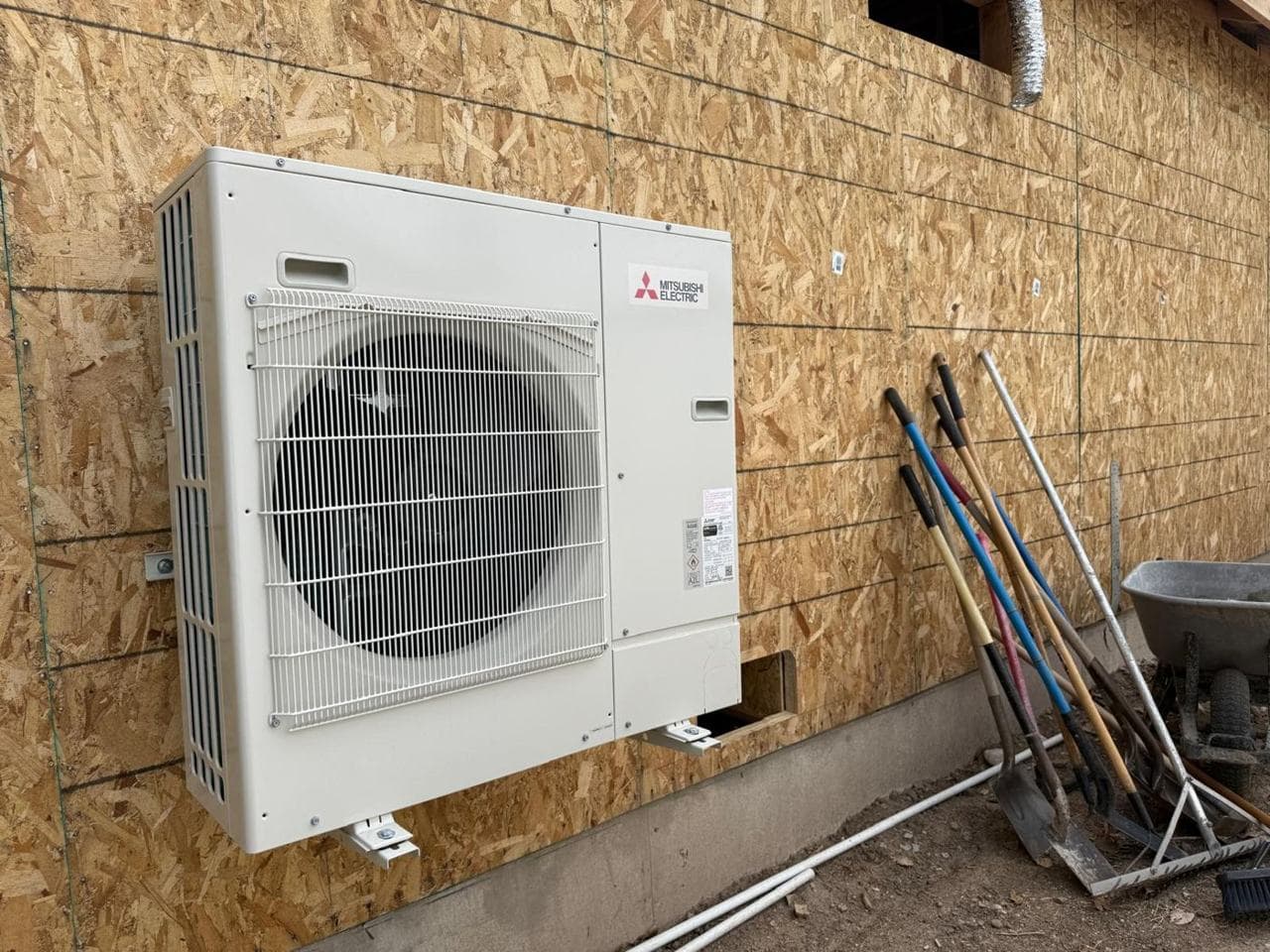 Outdoor heat pump unit mounted on the exterior wall