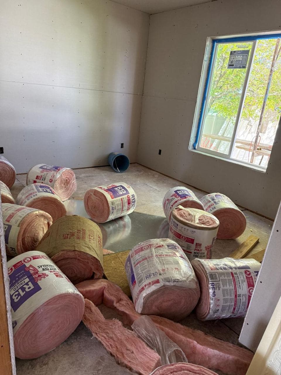 Rolls of insulation stacked below a new window