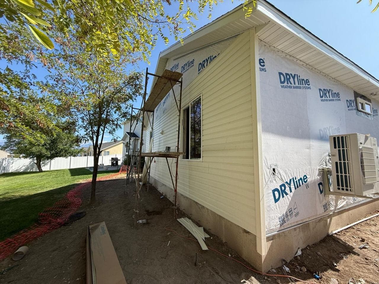Exterior wall with weather barrier, siding started and scaffolding in place