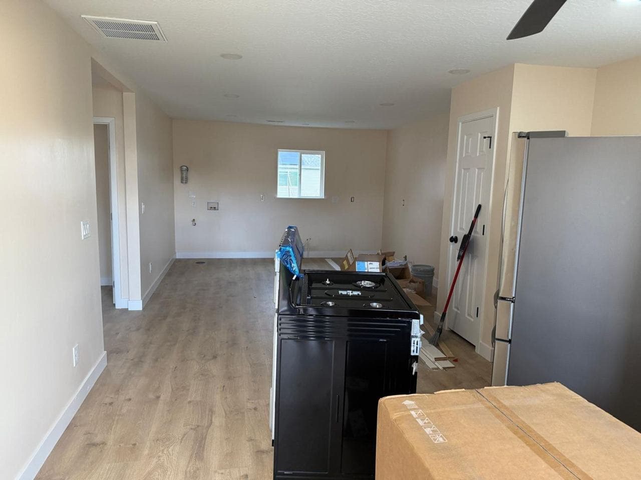 Open living and kitchen area with new flooring and appliances arriving