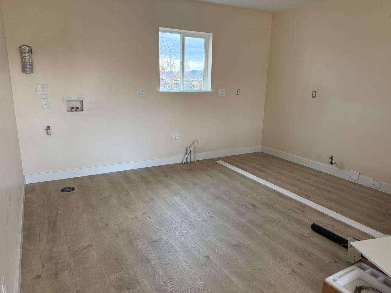 Laundry hookup wall with new flooring and trim