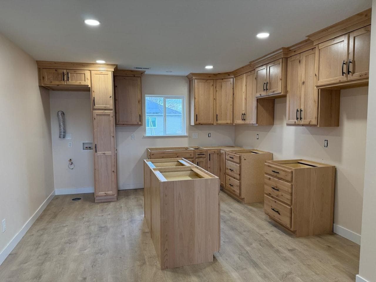 Kitchen with wood cabinets, an island and recessed lighting